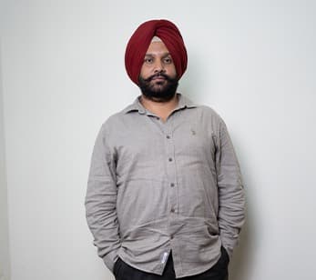 Dr. Arvinder Singh Bali, BAMS, standing against a plain wall