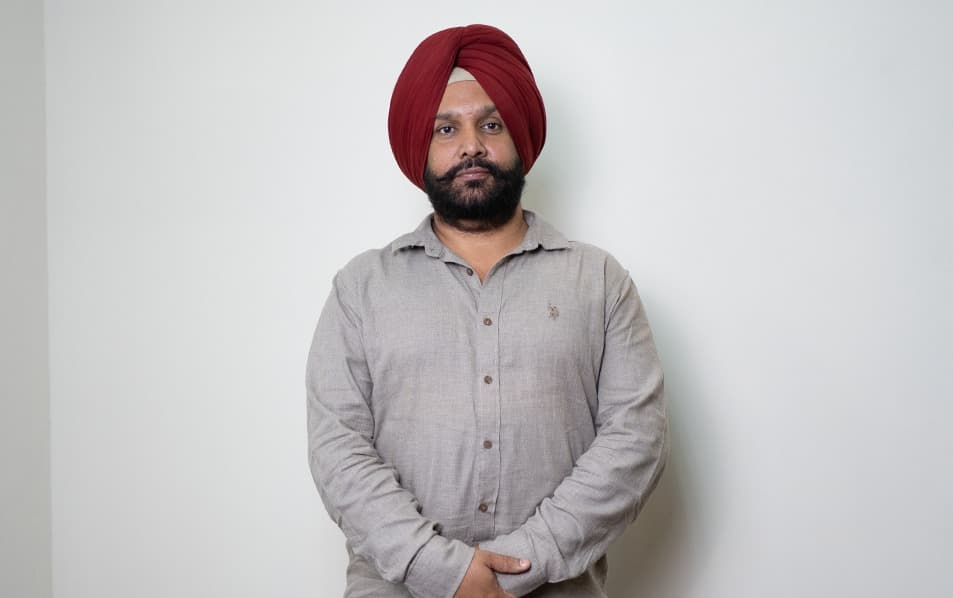 Dr. Arvinder Singh Bali, BAMS, hands folded, photographed for his online consultation practice